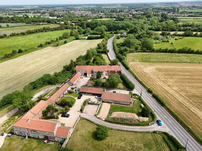 Wide aerial view showing a rural property, access road and surrounding fields near Doncaster.